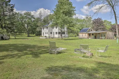 a group of chairs sitting in the grass in front of a house at Ashley Falls Home with Fire Pit Hike and Ski! in Ashley Falls