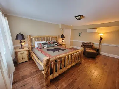 a bedroom with a wooden bed and a couch at The Hidden Inn in South Kortright