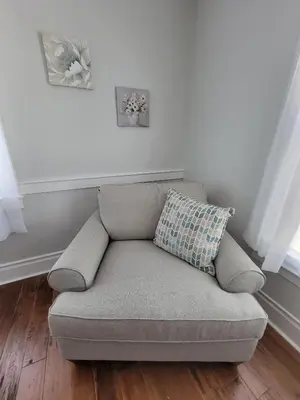 a couch sitting in a living room next to a window at The Hidden Inn in South Kortright