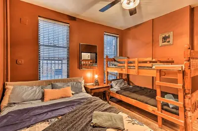 a bedroom with two bunk beds and a couch at 1850s historic Row House 7min train to NYC with private backyard in Jersey City