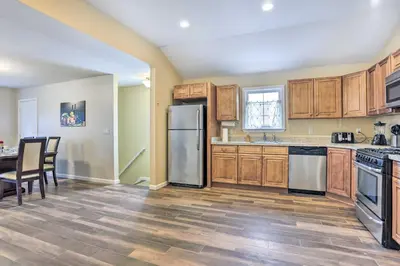a kitchen with wooden cabinets and stainless steel appliances at Ideally Located Glen Cove Apartment! in Glen Cove