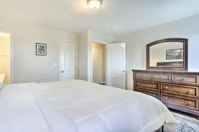 a bedroom with a bed and a dresser and a mirror at Ideally Located Glen Cove Apartment! in Glen Cove