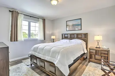 a bedroom with a large bed and a window at Ideally Located Glen Cove Apartment! in Glen Cove