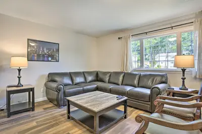 a living room with a leather couch and a table at Ideally Located Glen Cove Apartment! in Glen Cove