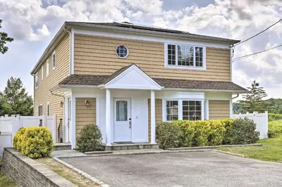 a house with a white fence in front of it at Ideally Located Glen Cove Apartment! in Glen Cove