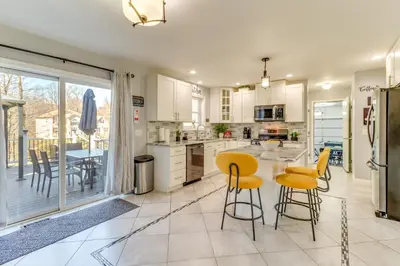 a kitchen with yellow stools and a table with a counter at Hot Tub! Family Tobyhanna Getaway 12 Mi to Slopes in Tobyhanna