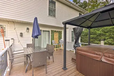 a patio with an umbrella and a table and chairs at Hot Tub! Family Tobyhanna Getaway 12 Mi to Slopes in Tobyhanna