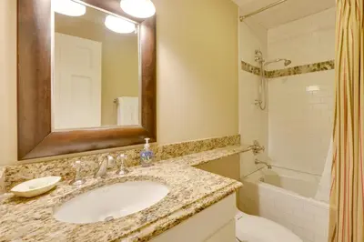 a bathroom with a sink and a toilet and a mirror at Stunning Warren Lakefront Home Deck, Grill, Sauna in Warren