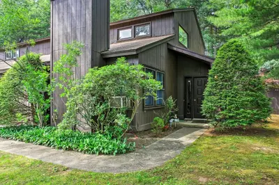 a house with a wooden facade and trees at Malta House with Pool 9 Mi to Saratoga Race Course! in Ballston Spa