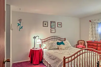 a bedroom with a bed and a table with a lamp at Malta House with Pool 9 Mi to Saratoga Race Course! in Ballston Spa