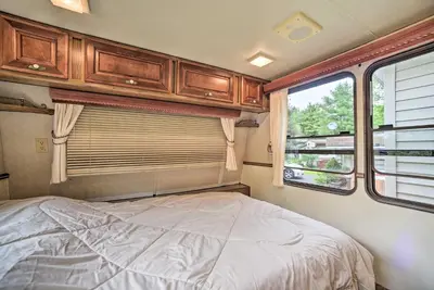a bedroom in an rv with a bed and a window at Glamping Getaway in Woodstock Lake Campground in East Berne