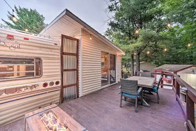 a wooden deck with a table and chairs on a house at Glamping Getaway in Woodstock Lake Campground in East Berne