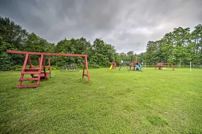 a park with several playground equipment in the grass at Glamping Getaway in Woodstock Lake Campground in East Berne