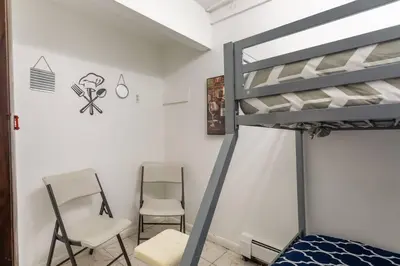 a bedroom with a bunk bed and two chairs at Sunset Estate in the Catskills in Monticello