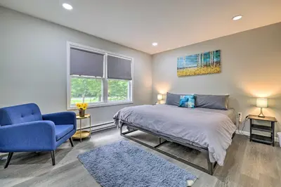 a bedroom with a bed and a blue chair at Furnished Deck and Lake Access Poconos Place! in Tobyhanna