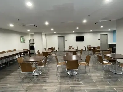 a dining room with tables and chairs and a flat screen tv at Days Inn by Wyndham Bronx NYC in Bronx