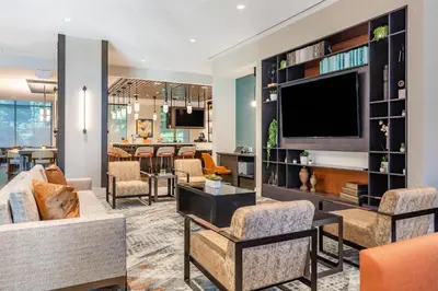 a living room with a couch and a tv at Cambria Hotel New Haven University Area in New Haven