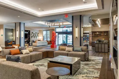a large living room with couches and a table at Cambria Hotel New Haven University Area in New Haven
