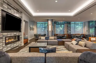 a living room with couches and a fireplace at Cambria Hotel New Haven University Area in New Haven