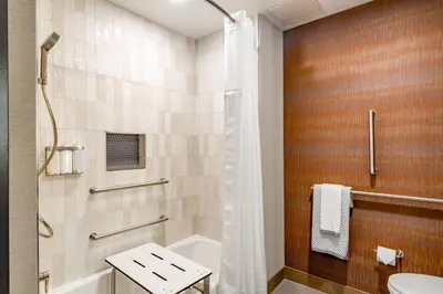 a bathroom with a shower and a toilet and a sink at Cambria Hotel New Haven University Area in New Haven