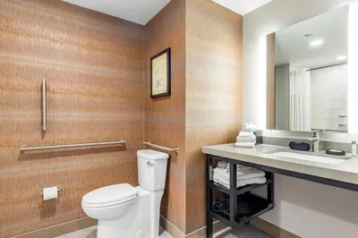 a bathroom with a toilet and a sink at Cambria Hotel New Haven University Area in New Haven