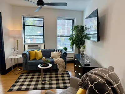 a living room with a blue couch and a table at Boutique Studio Apartment on Grand Ave in Englewood