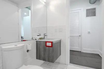 a white bathroom with a sink and a toilet at Dharma Home Suites Hoboken in Hoboken
