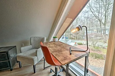 a room with a desk and a chair and a window at Golf, Ski and Fish Cabin with Deck in Tobyhanna! in Tobyhanna