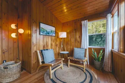 a room with two chairs and a table and a window at Camp Hudson Pines in Corinth