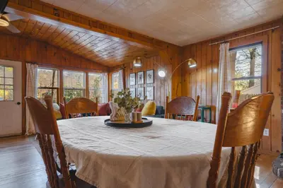 a dining room with a table and chairs at Camp Hudson Pines in Corinth