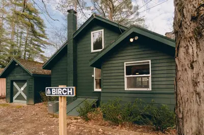 a green house with a street sign in front of it at Camp Hudson Pines in Corinth