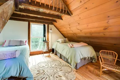 a bedroom with two beds in a log cabin at Breathtaking Mtn Views Stylish Rustic Retreat! in Bennington