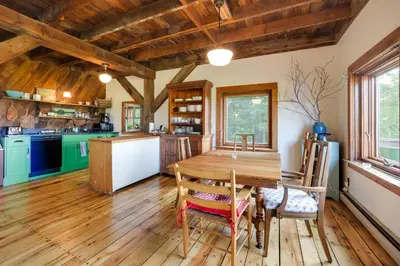 a kitchen and dining room with a wooden table and chairs at Breathtaking Mtn Views Stylish Rustic Retreat! in Bennington