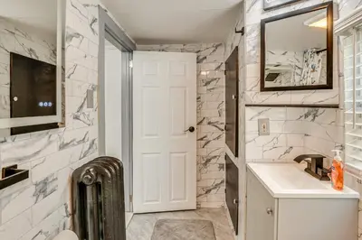 a bathroom with a sink and a mirror at 11 Mi to Manhattan Pet-Friendly Duplex with Yard! in Teaneck