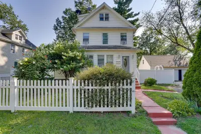a white picket fence in front of a house at 11 Mi to Manhattan Pet-Friendly Duplex with Yard! in Teaneck