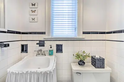 a white bathroom with a sink and a toilet at Walkable New Haven Retreat with Ocean Views! in New Haven
