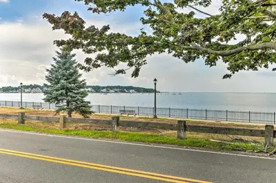 a road with a tree next to a body of water at Walkable New Haven Retreat with Ocean Views! in New Haven