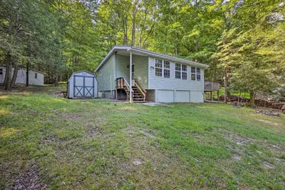 a small house with a garage on a yard at 22 Mi to Ski Big Bear! Lake Wallenpaupack Getaway in Greentown