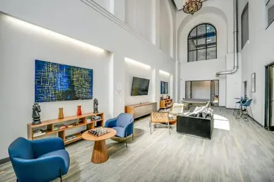 a large living room with blue chairs and a table at Elegant Main Street Living* Near NYC in Hackensack