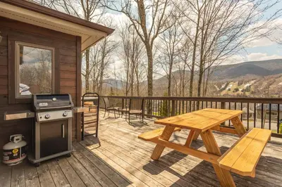 a wooden deck with a picnic table and a grill at Mountaintop Lookout with Hot Tub under the Stars in Hunter