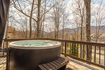 a hot tub on a deck with a view of the mountains at Mountaintop Lookout with Hot Tub under the Stars in Hunter