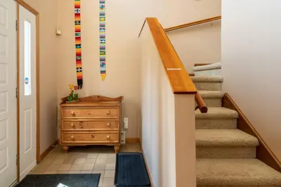 a hallway with stairs and a dresser in a house at Mountaintop Lookout with Hot Tub under the Stars in Hunter