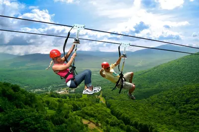 two people on a zip line in the mountains at Mountaintop Lookout with Hot Tub under the Stars in Hunter