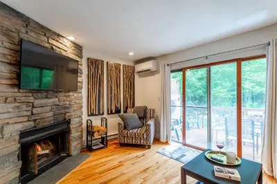 a living room with a fireplace and a tv at Redwood Retreat in Windham - minutes to Mtn! in Windham