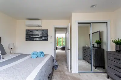 a bedroom with a large bed and a mirror at Redwood Retreat in Windham - minutes to Mtn! in Windham