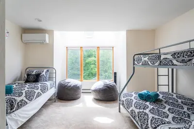 a bedroom with two bunk beds and a window at Redwood Retreat in Windham - minutes to Mtn! in Windham