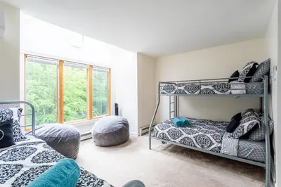 a bedroom with two bunk beds and a window at Redwood Retreat in Windham - minutes to Mtn! in Windham