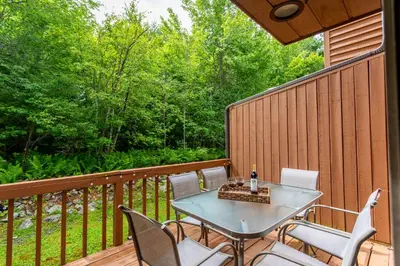a patio with a table and chairs on a deck at Redwood Retreat in Windham - minutes to Mtn! in Windham