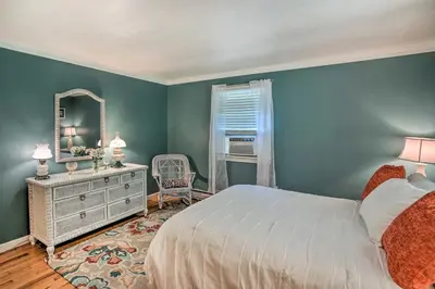 a bedroom with a bed and a mirror and a dresser at Stockbridge Home Walk to Town Beach! in Stockbridge