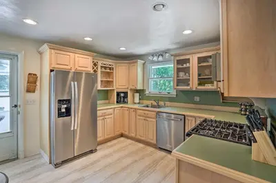 a kitchen with wooden cabinets and stainless steel appliances at Stockbridge Home Walk to Town Beach! in Stockbridge